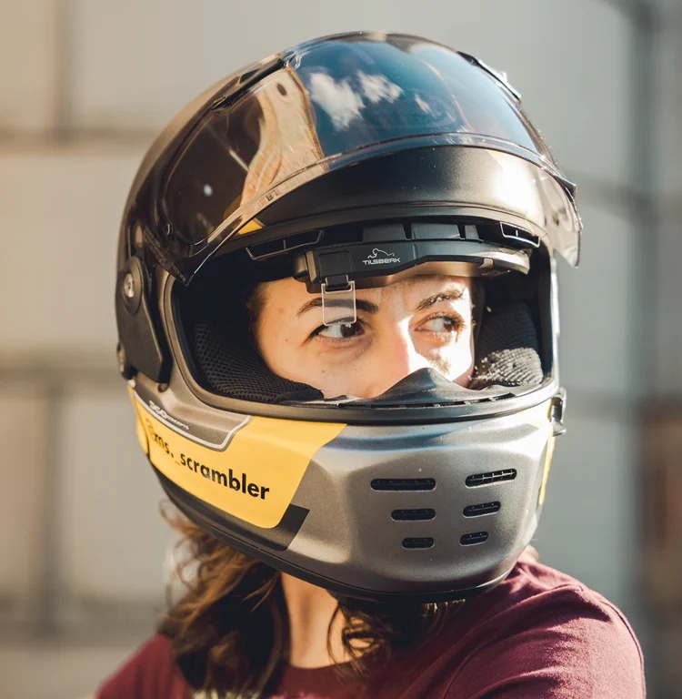 person indoor sitting table helmet woman standing glass wearing motorcycle wine young man holding plate blue player